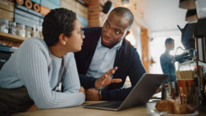 Two Diverse Entrepreneurs Have a Team Meeting in Their Stylish Café